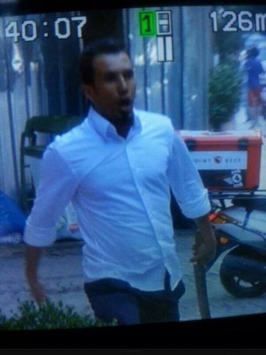 elinde pala ile halka saldıran insan